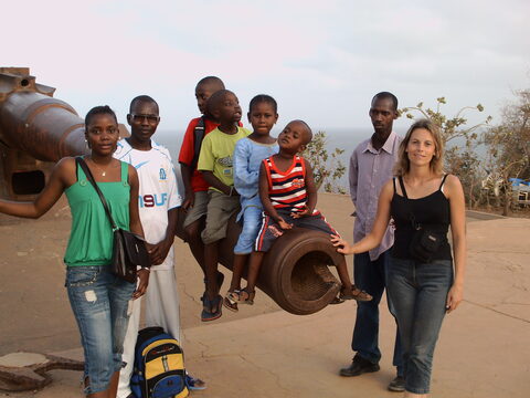 Groupe d'adultes et d'enfants près d'un canon ancien, en bord de mer