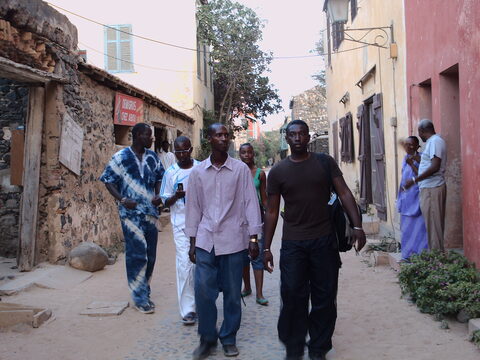 Groupe marchant dans une rue bordée de maisons de pierre
