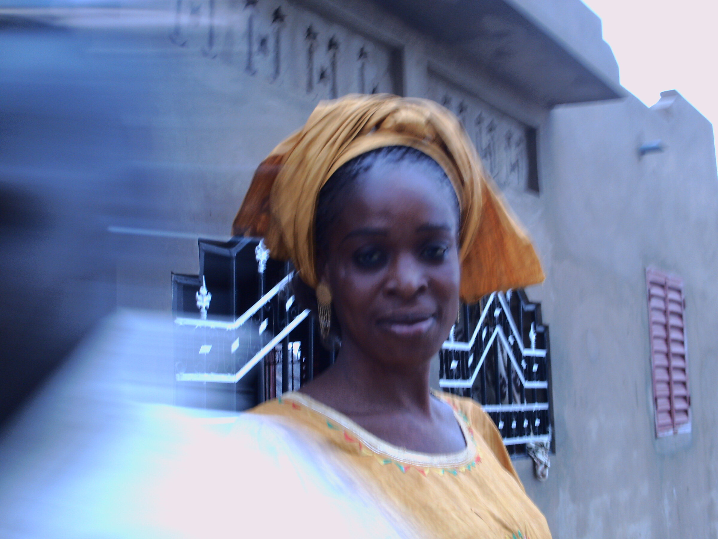Une femme au foulard doré, de face — cliché flou de bougé